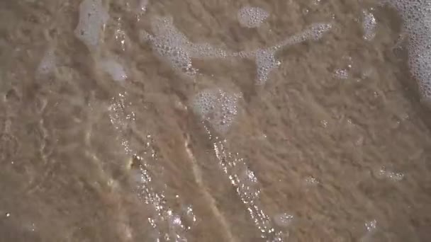 Волна на песчаном пляже в замедленной съемке. Концепция отпуска и путешествия — стоковое видео