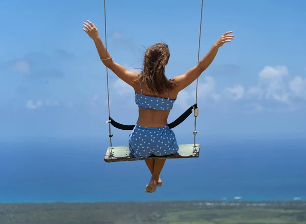 Jeune belle femme caucasienne sur le swing de corde avec fond de mer et de ciel. Concept de vacances et de voyage — Photo
