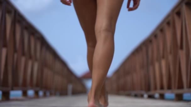 Jonge fitte vrouw in bikini die in slow motion op de pier loopt. Vakantie en reizen concept — Stockvideo