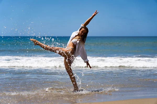 Молода радісна жінка в бікіні і білій сорочці насолоджується морем і свободою. " Щастя і безтурботність " — стокове фото