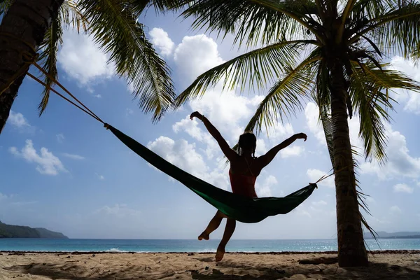 Silueta de mujer en hamaca con vistas a la playa tropical. Concepto de vacaciones y viajes — Foto de Stock