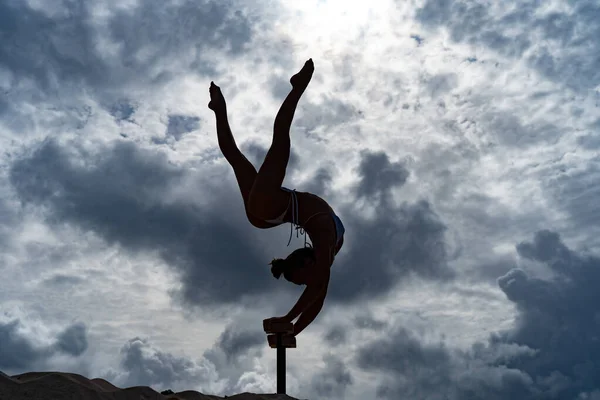Rugalmas női cirkusz Artist csinál kézenállás ellen csodálatos felhő táj. Akaraterő, potenciál és vágy fogalma — Stock Fotó
