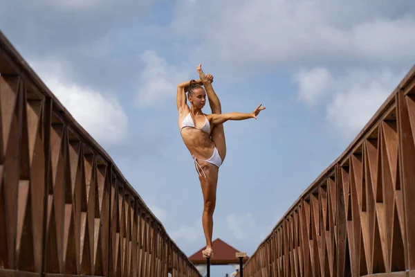 Artista de circo femenino flexible mantener el equilibrio en división en el puente. Motivación, pasión y concepto de logro — Foto de Stock
