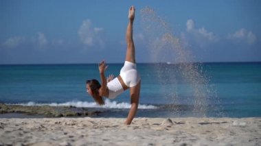 Kumsalda kumla ağır çekimde dans eden esnek, genç bir kadın. Özgürlük, Bireysellik ve Özgünlük Konsepti 