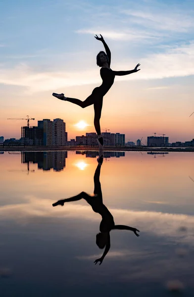 Silueta de bailarina actuando al aire libre durante el atardecer. Concepto de individualidad, creatividad y confianza en sí mismo — Foto de Stock