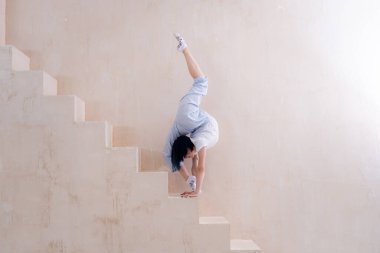 Esnek kız stüdyoda esneme hareketleri yapıyor. İrade, motivasyon ve sağlıklı yaşam tarzı kavramı