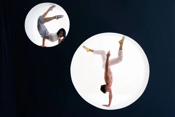 Flexibel tjej och man gör stretching och handstand i studio. Begreppet individualitet, kreativitet och självförtroende — Stockfoto