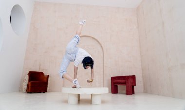 Esnek kadın bir elinde denge tutarken akıllı telefon evde. Yoga, bireysellik ve yaratıcılık kavramı 