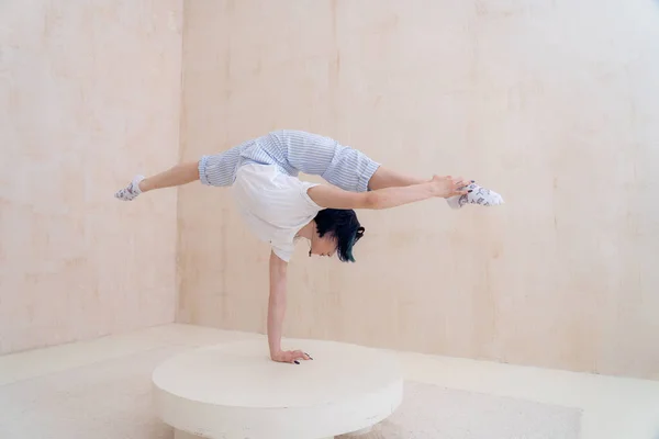 Flexibele meisje praktijk stretching en handstand thuis. concept van gezonde levensstijl en yoga — Stockfoto
