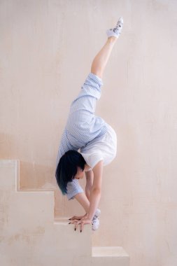 Esnek kız stüdyoda esneme hareketleri yapıyor. İrade, motivasyon ve sağlıklı yaşam tarzı kavramı