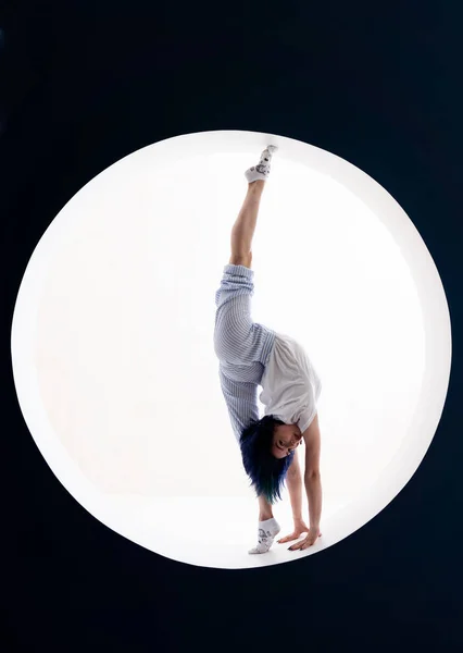Flexibel tjej gör stretching och handställ i studio. Begreppet individualitet, kreativitet och självförtroende — Stockfoto
