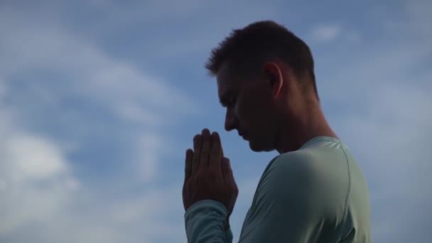 Jeune homme prie sur fond de ciel bleu. Repentance, regret et espoir concept — Video