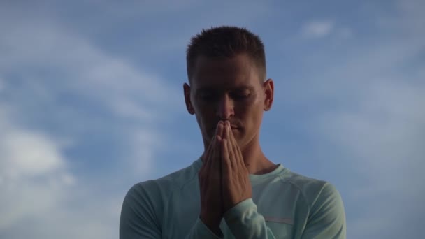 Jeune homme prie sur fond de ciel bleu. Repentance, regret et espoir concept — Video