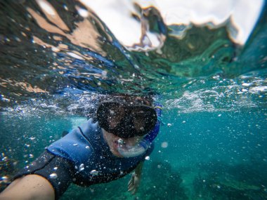 Şnorkel maskeli bir adam suyun altında selfie çekiyor. Macera ve seyahat konsepti.