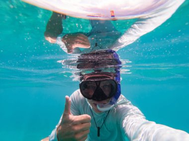Adam su altında şnorkelle yüzüyor. Seyahat ve tatil kavramı 