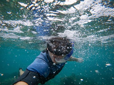 Şnorkel maskeli bir adam suyun altında selfie çekiyor. Tatil, serbest dalış ve seyahat konsepti.