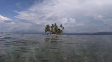 Hindistan cevizi palmiyeleri temiz suyla ağır çekimde küçük tropikal bir ada. Macera ve seyahat konsepti 