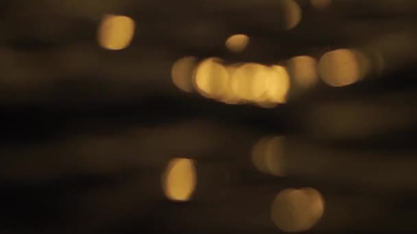 Нежная золотая текстура bokeh бликов на воде во время заката и рассвета в замедленной съемке — стоковое видео