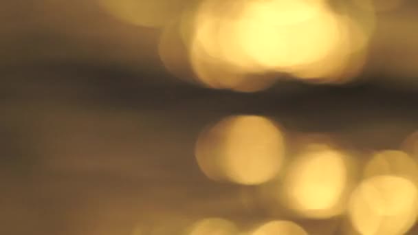 Delicate gouden textuur bokeh van verblinding op het water tijdens zonsondergang en zonsopgang in slow motion — Stockvideo