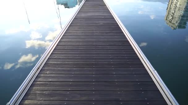 Muelle vacío de madera al mar en el puerto deportivo al amanecer con nubes en reflexión. Concepto de viajes y vacaciones — Vídeos de Stock