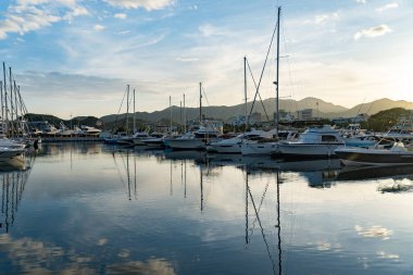 Gün batımında rıhtımda bir sürü yelkenliyle lüks Marina manzarası 