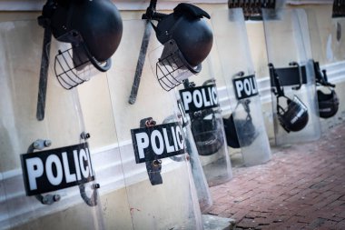 Sokaktaki kalkan ve miğfer gibi polis ekipmanları. Koruma ve güç kavramı