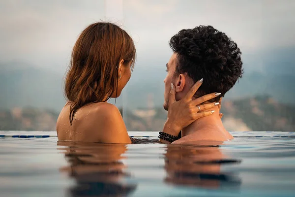 Pareja amorosa en el agua del polo infinito durante el atardecer. Concepto romántico de vacaciones —  Fotos de Stock