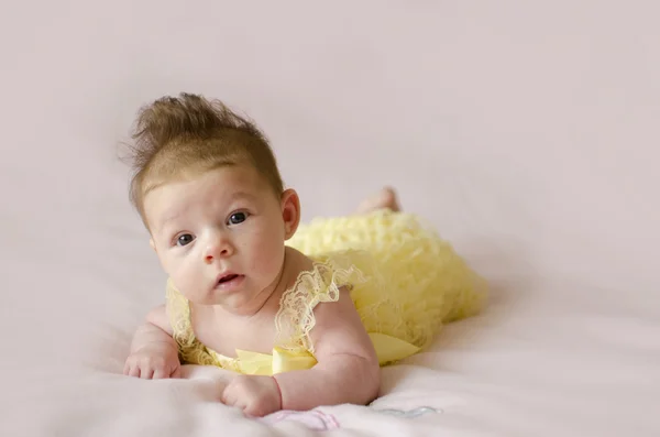 Mooie babymeisje liggend op de buik Rechtenvrije Stockfoto's