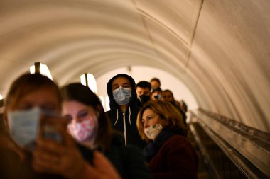 Sağlık önlemlerine uygun olarak metrodaki yürüyen merdivendeki yolcular koruyucu maskeler takıyorlar..