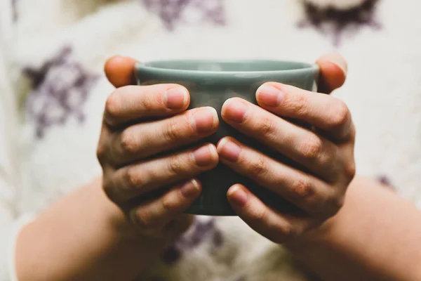 Elinde sıcak kakao ya da kahve fincanı tutan genç bir kadın. Sonbahar ya da kış karamsar hafta sonu, yeni yıl ve Noel geçmişi. Tembel bir gün, hafif bir kahvaltı, karantina, evde kal, rahat sahne, kızlık zarı konsepti..