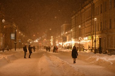 Kyiv, Ukrayna - 11 Şubat 2021: Karlı bir sokakta insanlar yürüyor. Kyiv şehri bir kar fırtınasıyla kaplıydı. Kar temizleme ekipmanları tam kapasite çalışıyor. Hava gerçek bir kışa dönüştü..