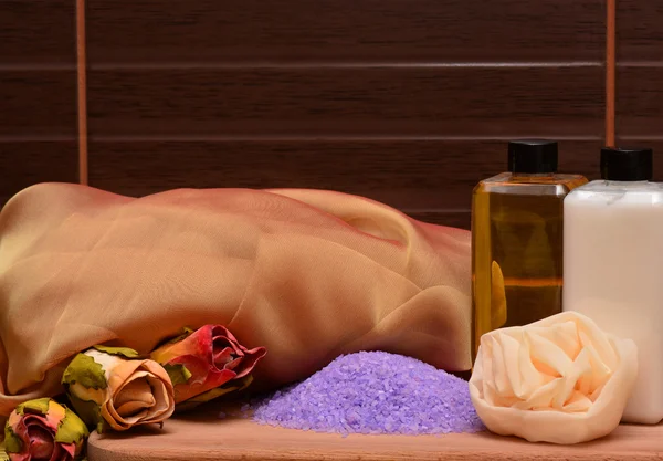 Kosmetika och utrustning för spa: massage svamp, violett havssalt, bodylotion, shower gel, blommor — Stockfoto
