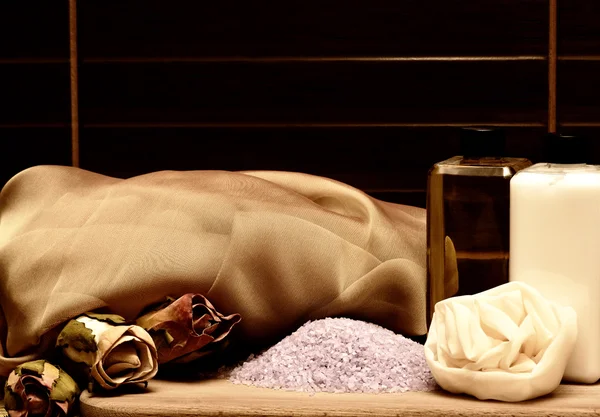 Косметика и оборудование для спа: массажная губка, фиолетовая морская соль, лосьон для тела, гель для душа, цветы, тонировка сепии — стоковое фото