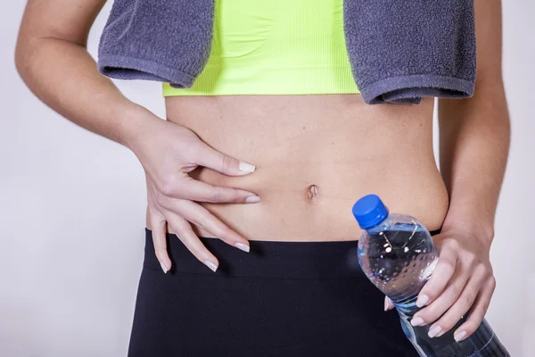 Woman after fitness training, pinches fat on the belly — Stock Photo, Image