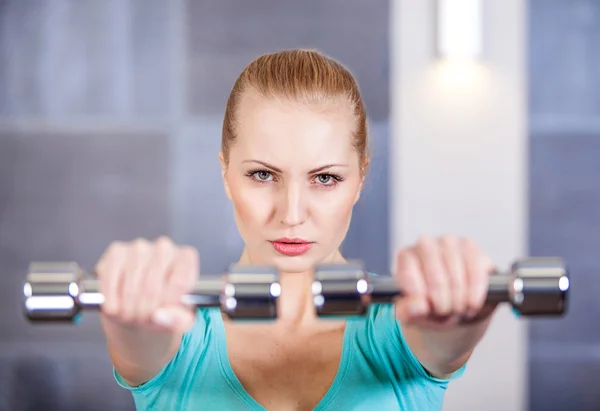 Mujer joven haciendo ejercicio con pesas en el hombro de entrenamiento del gimnasio —  Fotos de Stock