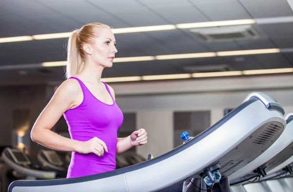 Atractiva joven corriendo en una cinta de correr, ejercicio en el gimnasio —  Fotos de Stock