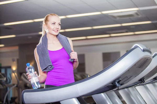 Attractive young woman after running on a treadmill, exercise at the fitness club — Stock Photo, Image