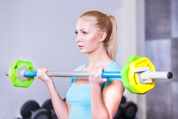 Young beautiful strong blond woman with barbell and weight plates — Stock Photo, Image