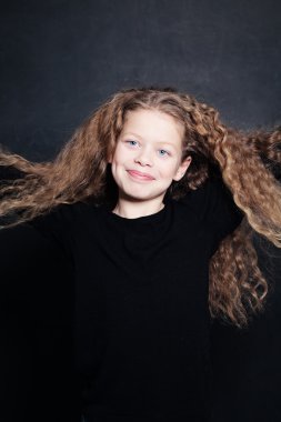 Uzun kıvırcık saçlı kız çocuk gülümseyen