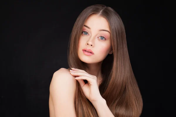 Schöne Frau mit langen braunen Haaren auf schwarzem Hintergrund — Stockfoto