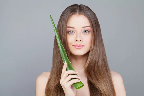 Kvinna med tydliga hud och långt och friskt hår Holding grön Aloe L — Stockfoto