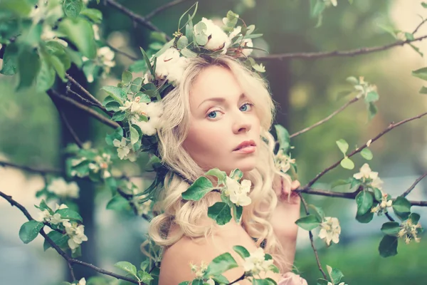 Bella donna con i capelli biondi su sfondo fiore di primavera — Foto Stock