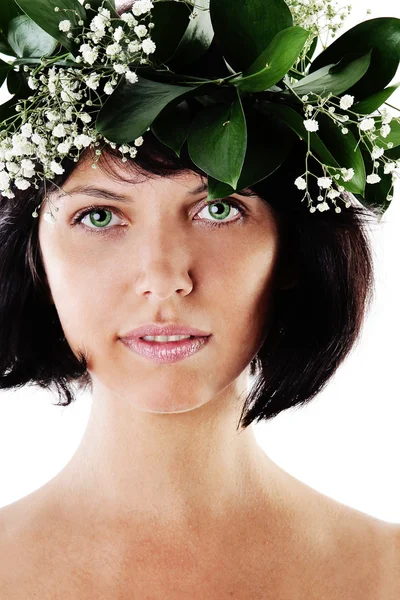 Mooie vrouw met groene bladeren en bloemen. — Stockfoto