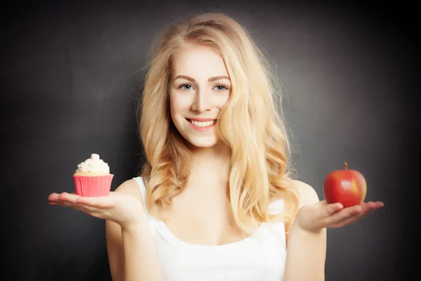 Dieta. Mujer sana sosteniendo manzana roja y pastel — Foto de Stock