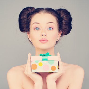 Güzel bir kadın hediye kutusunu tutuyor.
