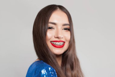 Diş telleri beyaz arka planda gülümseyen mükemmel başarılı kadın.