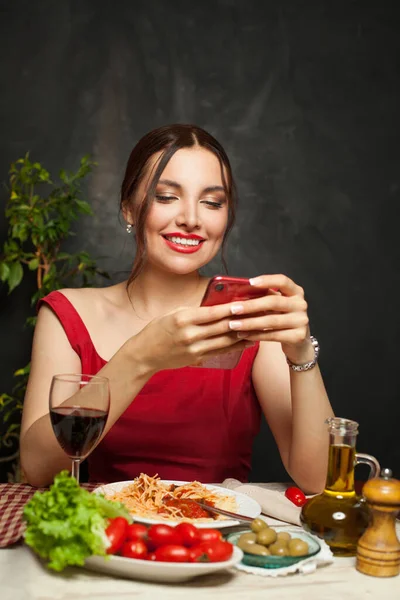 Όμορφη Γυναίκα Που Χρησιμοποιεί Τηλέφωνο Κουβεντιάζοντας Και Τρώγοντας Ιταλικά Μακαρόνια — Φωτογραφία Αρχείου