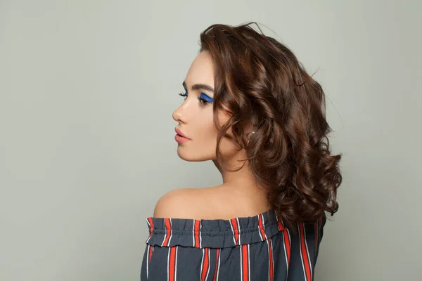 Привлекательная Молодая Женщина Каштановыми Вьющимися Волосами Сером Фоне — стоковое фото