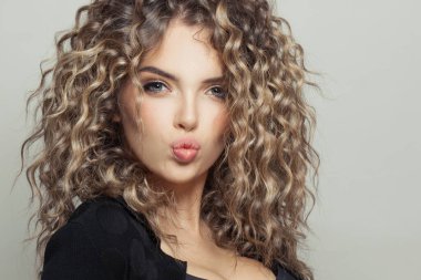 Beyaz arka planda sağlıklı kıvırcık saçlı güzel model kadın, moda portresini kapat.