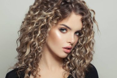 Beyaz arka plan portresi üzerinde kıvırcık saçlı, ombre ve kıvırcık saçlı mükemmel bir model kadın.